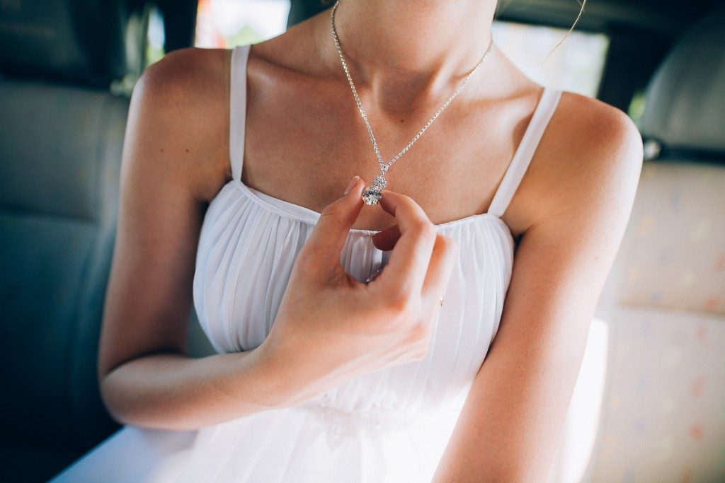 Woman holding her silver necklace