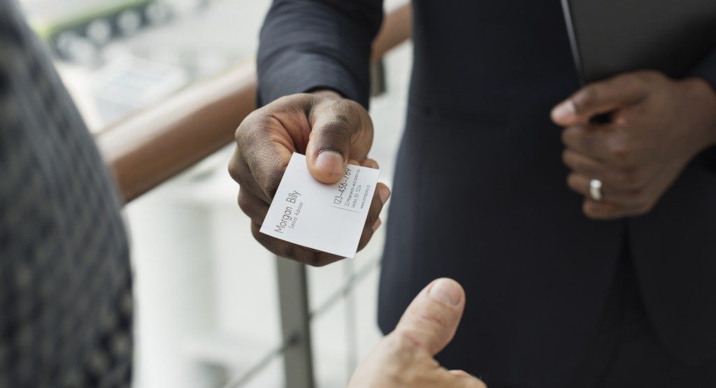 businessman giving business card to other person