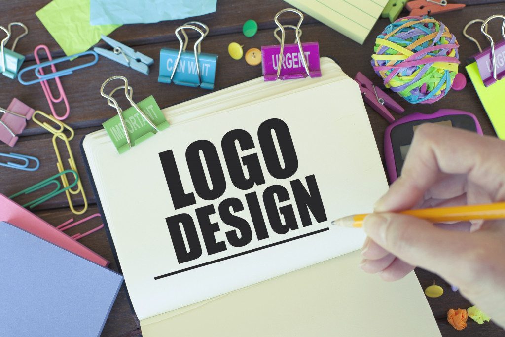person drawing logo design on paper