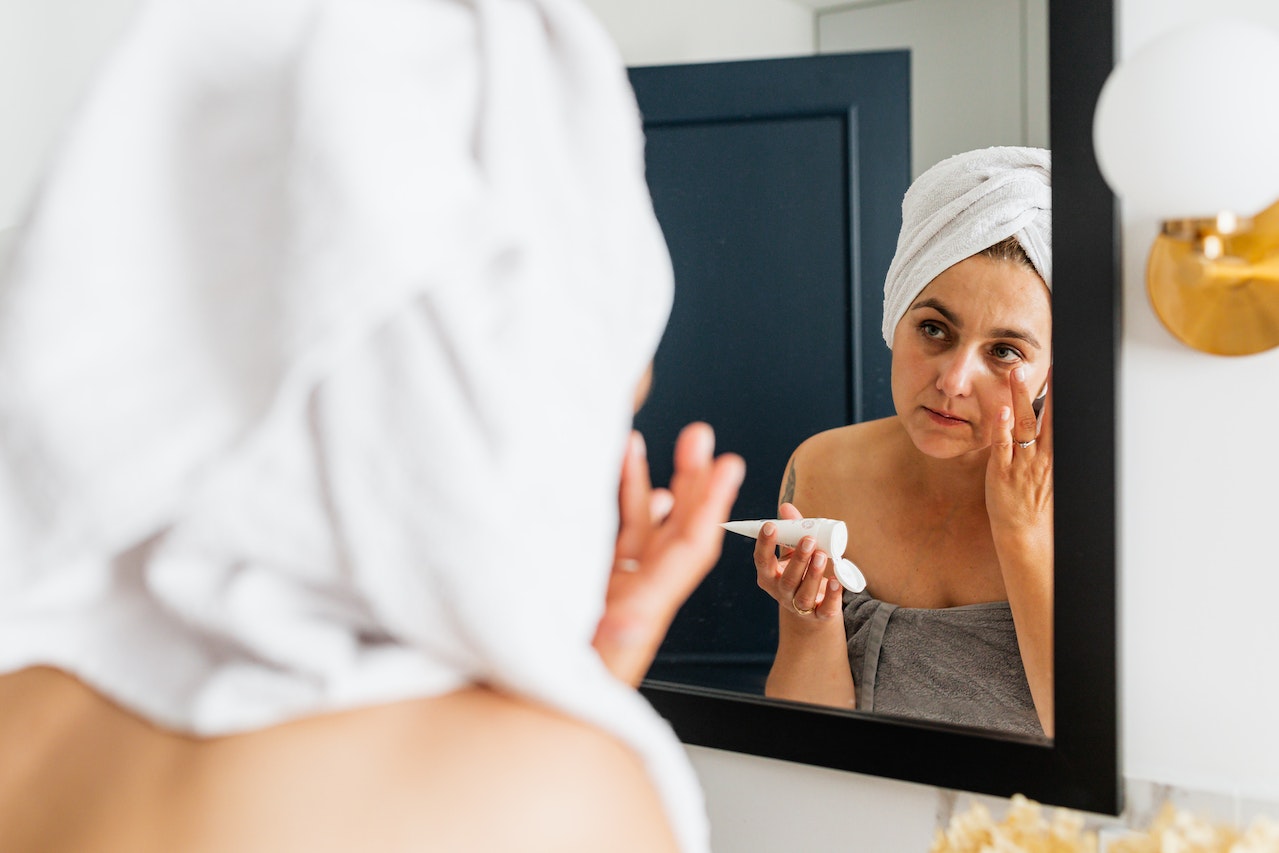 a woman applying face moisturizer